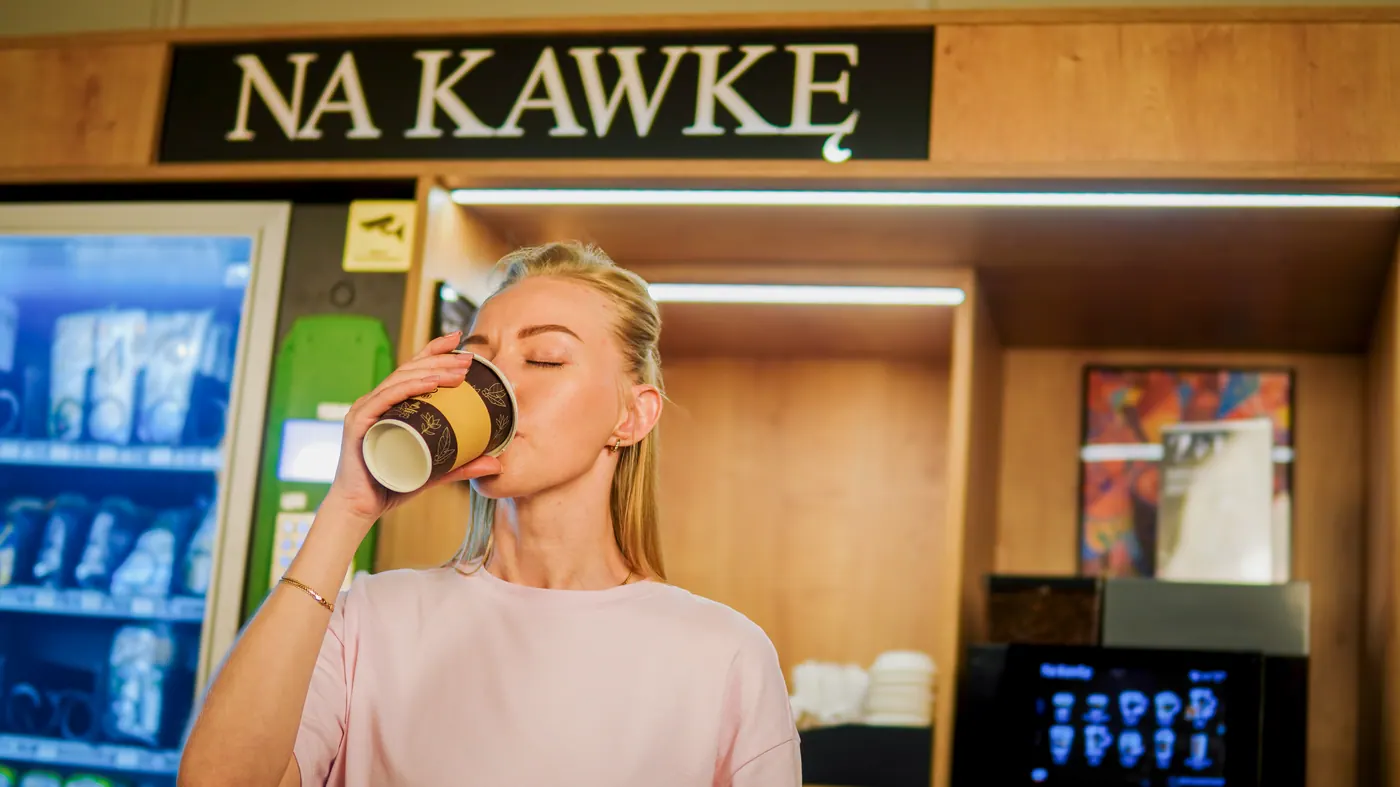 Klientka odbiera kawę z punktu Na Kawkę